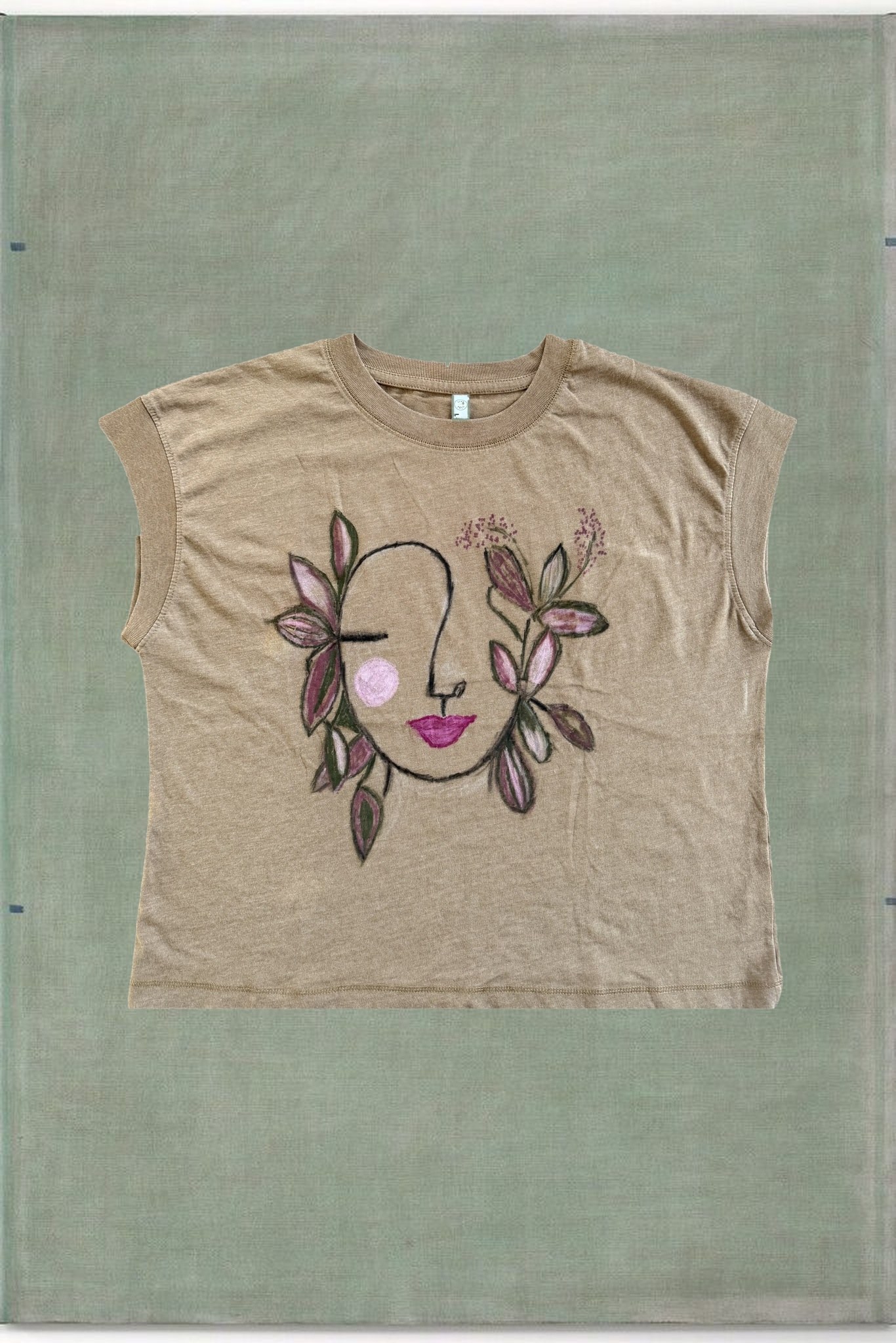 Floral Face Relaxed Tee, hand-painted face with leaves, styled over sage green canvas