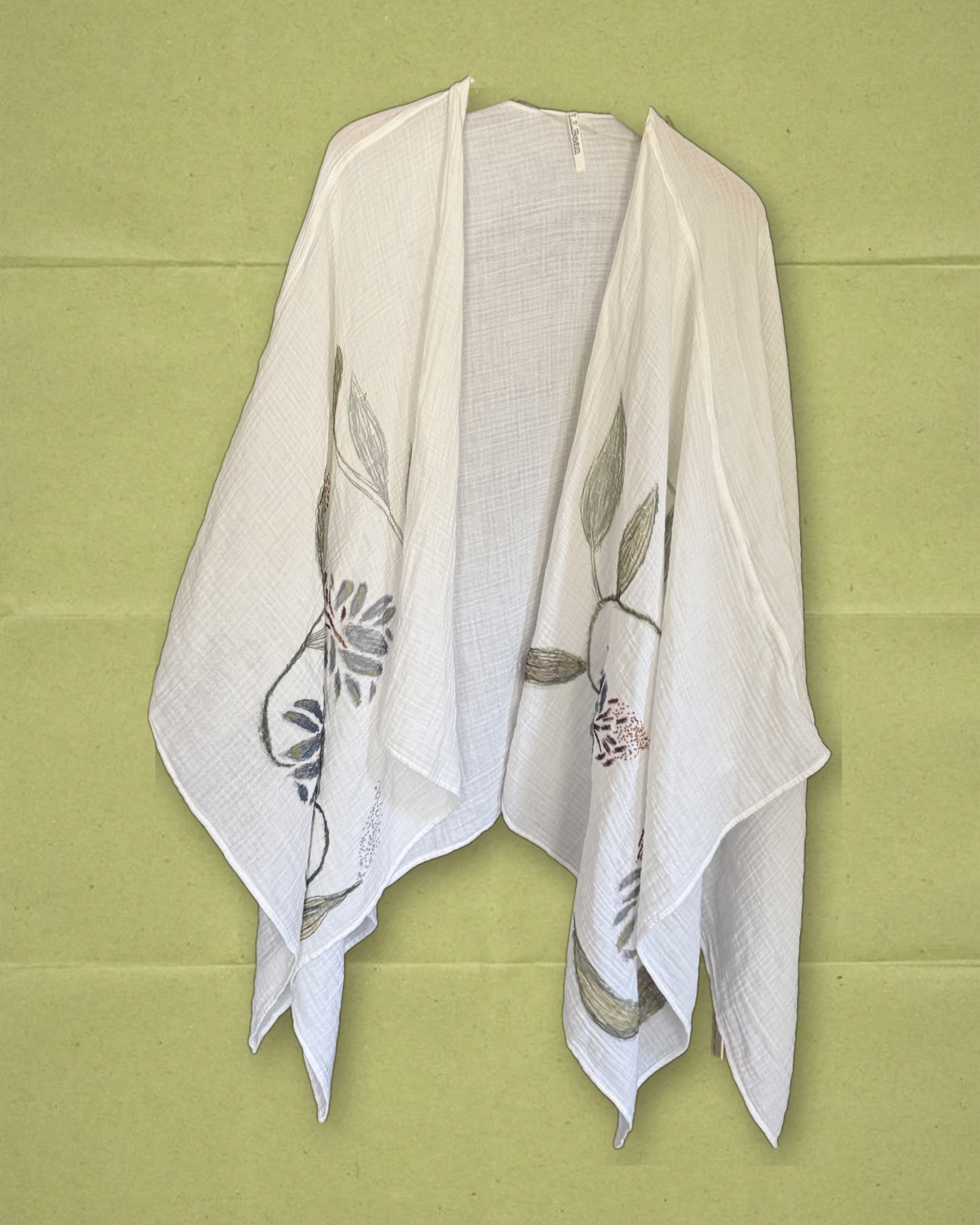 Hand-painted floral shawl worn open, styled over olive paper