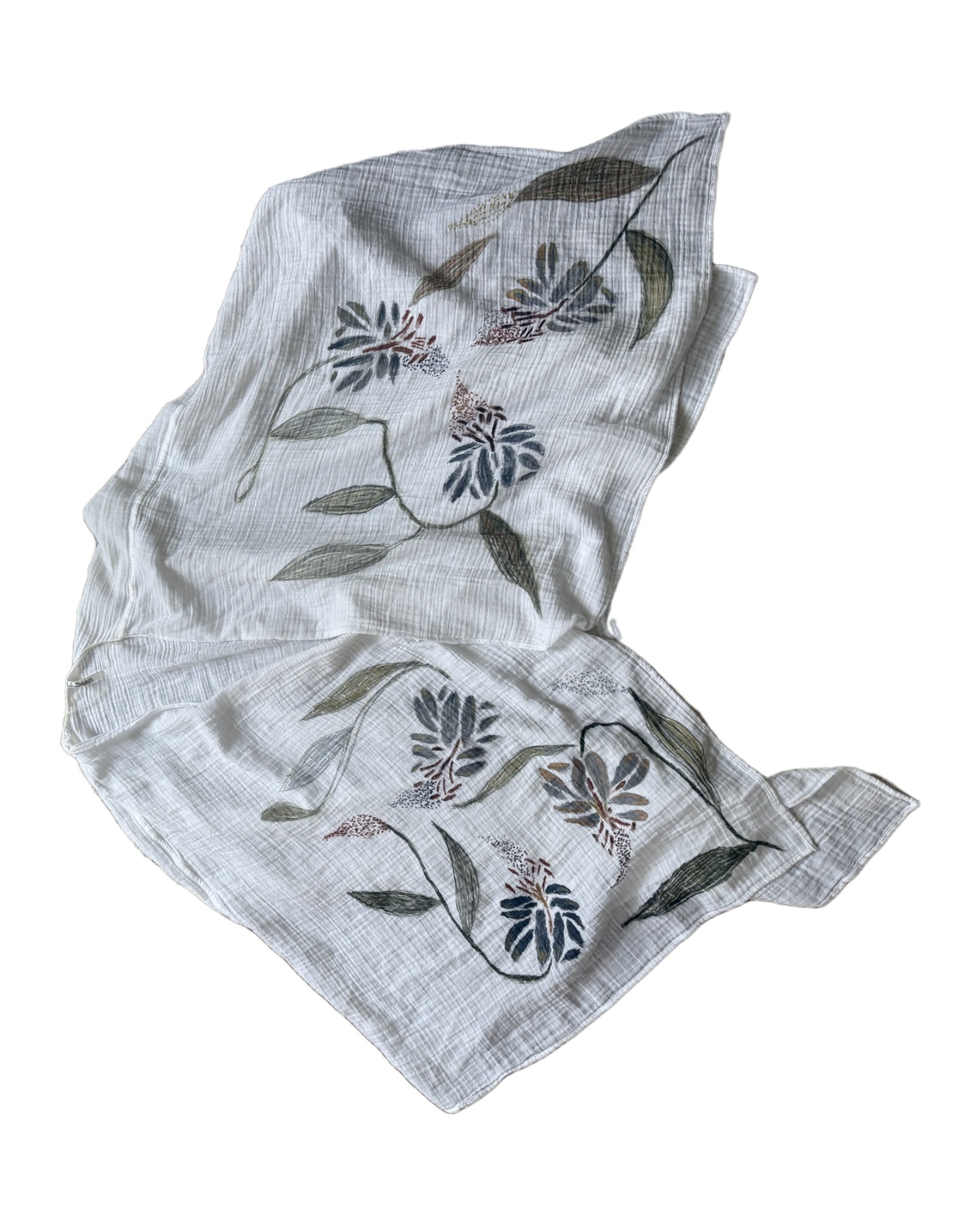 Hand-painted shawl laid in a soft drape on white